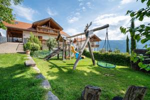 a house with a playground in the yard at Stettnerhof Wohnung Penegal in Vollan
