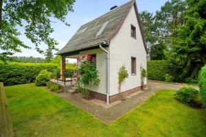 a small white house with a porch and flowers at Ferienhaus Carpin in Carpin