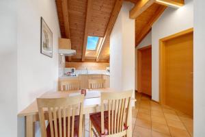 a kitchen with a wooden ceiling and a table and chairs at Stettnerhof Wohnung Penegal in Vollan +16 photos