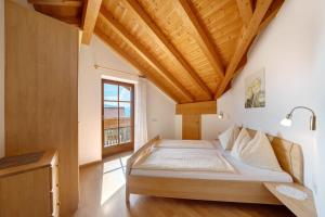 a bedroom with a bed with a wooden ceiling at Stettnerhof Wohnung Penegal in Vollan