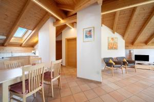 a kitchen and dining room with a table and chairs at Stettnerhof Wohnung Penegal in Vollan