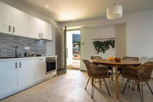 a kitchen with a table and chairs in a room at Joy Breeze in Kefallonia +19 photos