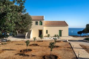 a house with trees in front of the ocean at Joy Breeze in Kefallonia
