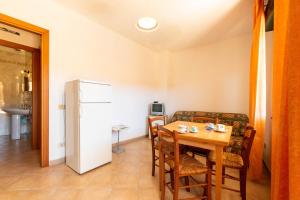 a dining room with a table and a refrigerator at Appartamenti Cavour cod C in Villasimius