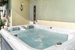 a bath tub with blue water in it at Ferienwohnung Schwarzwaldmädel in Seelbach +24 photos