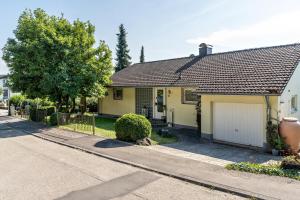a yellow house with a garage on a street at Ferienwohnung Schwarzwaldmädel in Seelbach