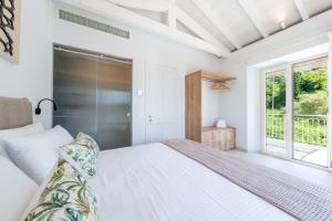 a white bedroom with a bed and a window at The Olive Yard Corfu Sidari in Karousádes +17 photos