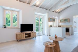 a living room with a tv and a kitchen at The Olive Yard Corfu Sidari in Karousádes