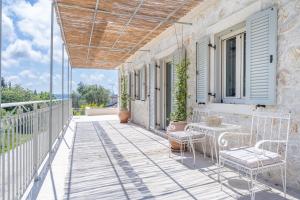 a balcony with a table and chairs on a house at The Olive Yard Corfu Sidari in Karousádes