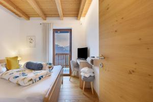 a bedroom with a bed and a desk and a window at Löchlerhof in Ritten