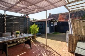 a patio with a table and a pergola at Ferienhaus Segelboot in Krummhörn