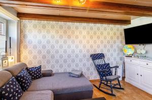 a living room with a couch and a chair at Ferienhaus Segelboot in Krummhörn