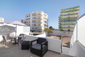a balcony with a table and chairs and a building at Telmus Villa 1 andar in Monte Gordo