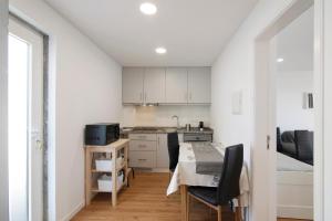 a kitchen and dining room with a table and chairs at Telmus Villa 1 andar in Monte Gordo