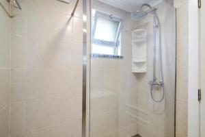 a shower with a glass door in a bathroom at Telmus Villa 1 andar in Monte Gordo +15 photos