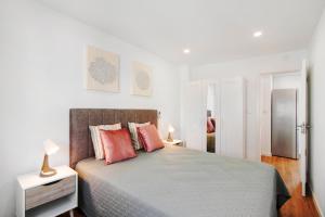 a bedroom with a large bed with red pillows at Telmus Villa 1 andar in Monte Gordo