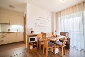 a kitchen and dining room with a table and chairs at Schnitzer Ferienwohnung Löwenzahn in Rablà