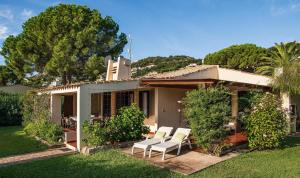 a house with white chairs in the yard at Villa Romana in Costa Rei