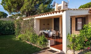 a white house with a table in the backyard at Villa Romana in Costa Rei +18 photos