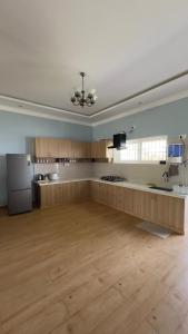 a large kitchen with wooden floors and a ceiling at Yak villa in Kushālnagar +6 photos