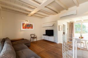 a living room with a couch and a tv at Appartamento Bacco in Lido di Camaiore