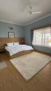 a bedroom with a large bed and a rug at Yak villa in Kushālnagar