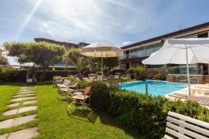 a pool with chairs and umbrellas next to a building at Appartamento Bacco in Lido di Camaiore