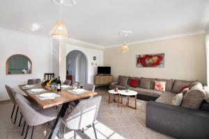 a living room with a table and a couch at Villa Martinique in Albufeira