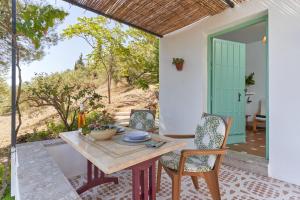 a table and chairs on a patio with a door at Cortijo de Arriba in Frigiliana +21 photos