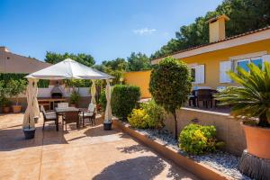 a patio with a table and an umbrella at S'oratge in Can Picafort