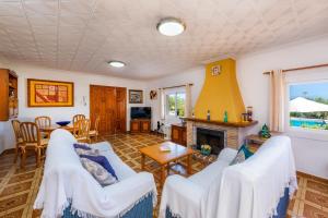 a living room with white furniture and a fireplace at S'oratge in Can Picafort