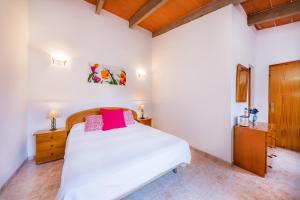 a bedroom with a white bed and a wooden cabinet at S'oratge in Can Picafort +21 photos