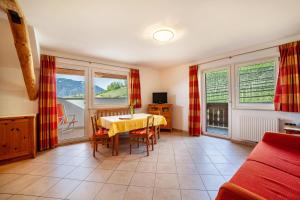 a living room with a table and some windows at Gasserhof Ferienwohnung Jonagold in Caines