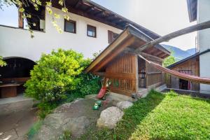 a backyard with a wooden house with a swing at Gasserhof Ferienwohnung Jonagold in Caines