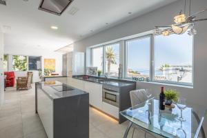 a kitchen with a glass table and some windows at Sai Gayatri in Nerja