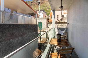 a balcony with a table and chair on a building at Casa do Porto in Paul do Mar
