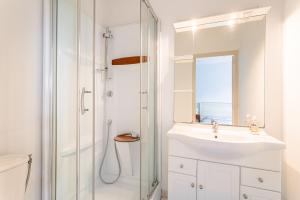 a white bathroom with a sink and a shower at Maison d'hôtes Le Grillon in La Brée-les-Bains