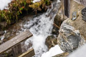 a wooden bench next to a stream of water at Goodlife Top 1 in Saalbach-Hinterglemm