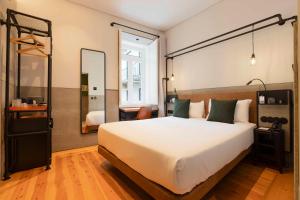 a bedroom with a large bed and a mirror at Inspira Santos Boutique Hotel in Lisbon