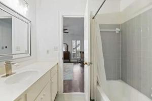 a white bathroom with a sink and a shower at Red Bluff Cottage in Montgomery