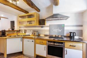 a kitchen with white cabinets and a stove top oven at Fachwerk-Ferienhaus 1764 in Eslohe