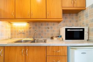 a kitchen with a sink and a microwave at Spyridoula Studio 10 in Paleokastritsa +24 photos