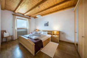a bedroom with a bed and a large window at Eichernhof Apartment Marillenblüte in Verano