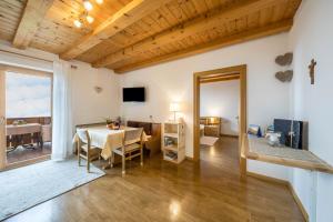a living room with a table and a dining room at Eichernhof Apartment Marillenblüte in Verano