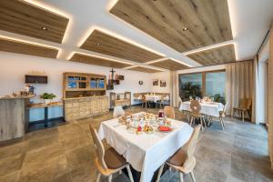 a dining room with tables and chairs and a kitchen at Eichernhof Apartment Marillenblüte in Verano +23 photos