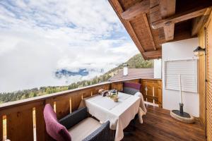 a room with a table and chairs on a balcony at Eichernhof Apartment Marillenblüte in Verano
