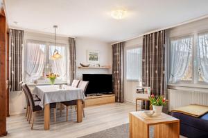 a living room with a dining table and a tv at Ferienwohnung Dachtler in Hinterzarten