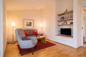 a living room with a couch and a television at Pfirsichblüte in Lindau
