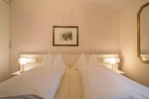 a bedroom with two beds with white pillows at Pfirsichblüte in Lindau
