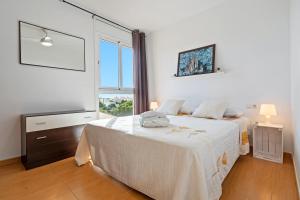 a bedroom with a bed and a large window at Dorada Apartment Sol in Calafell +12 photos